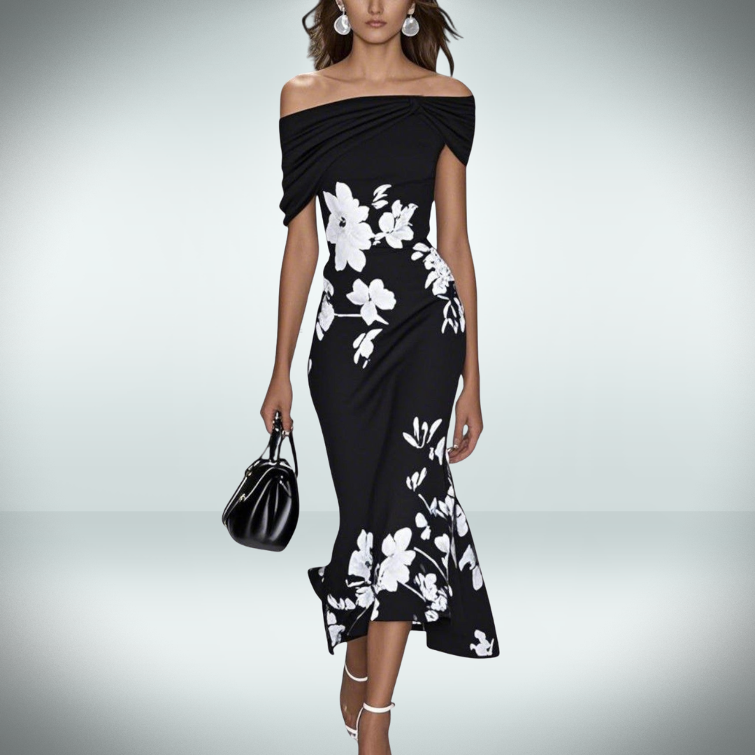 Woman wearing a black off-shoulder dress with white floral patterns on a gray background