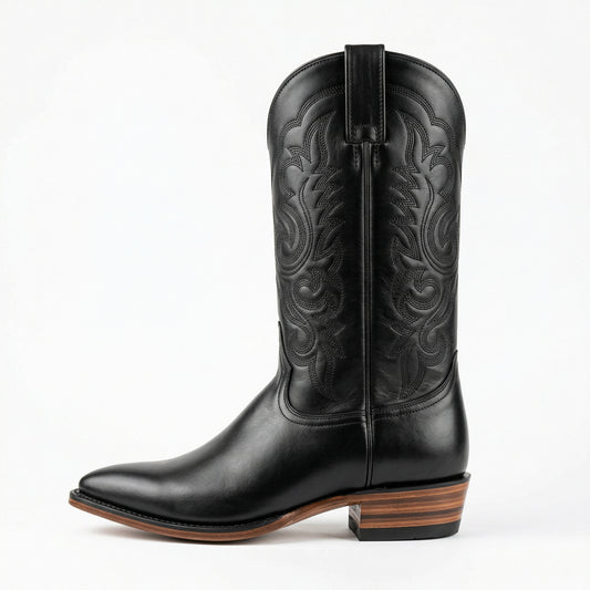 Black cowboy boot with intricate embossing on a white background