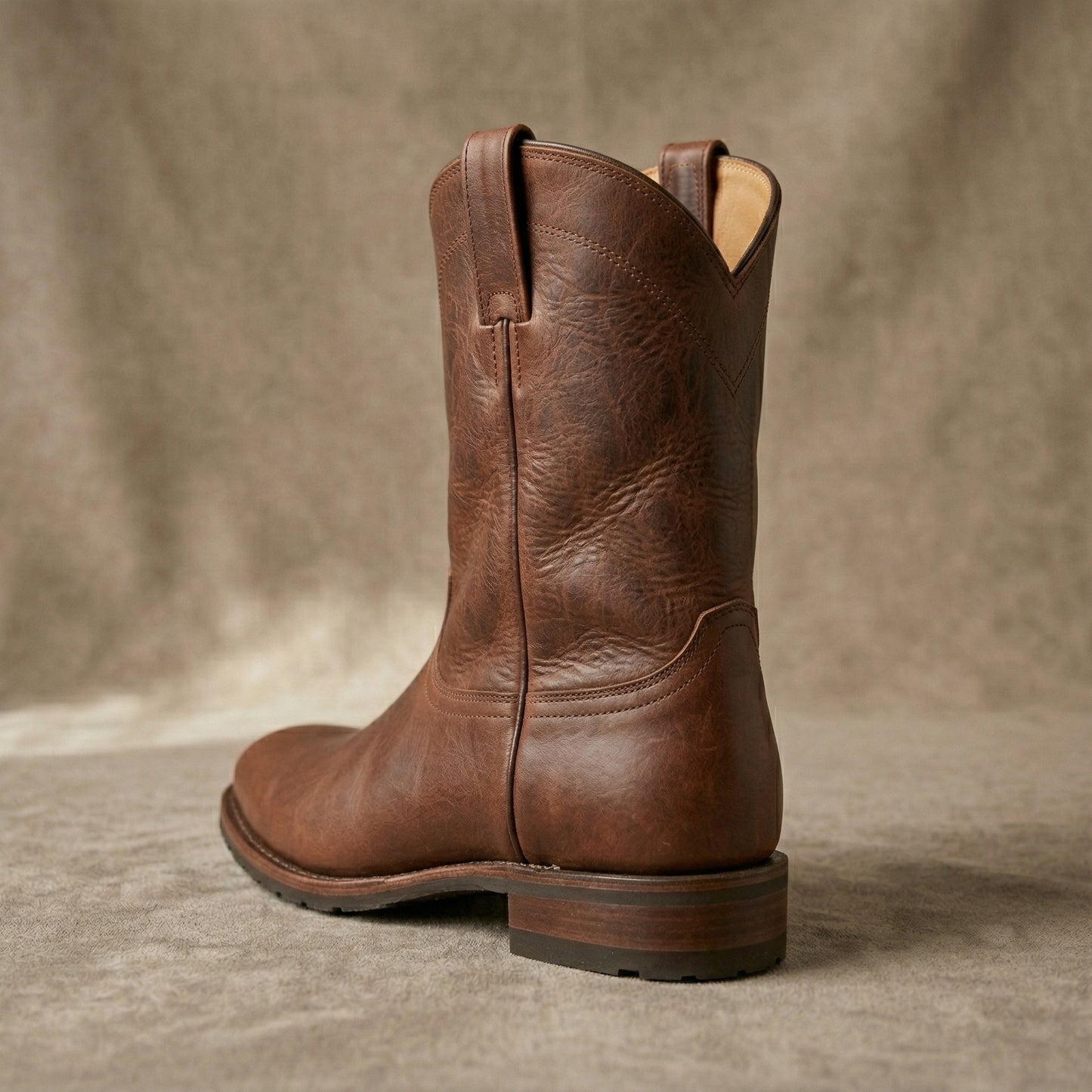 Brown leather boot on a textured brown background