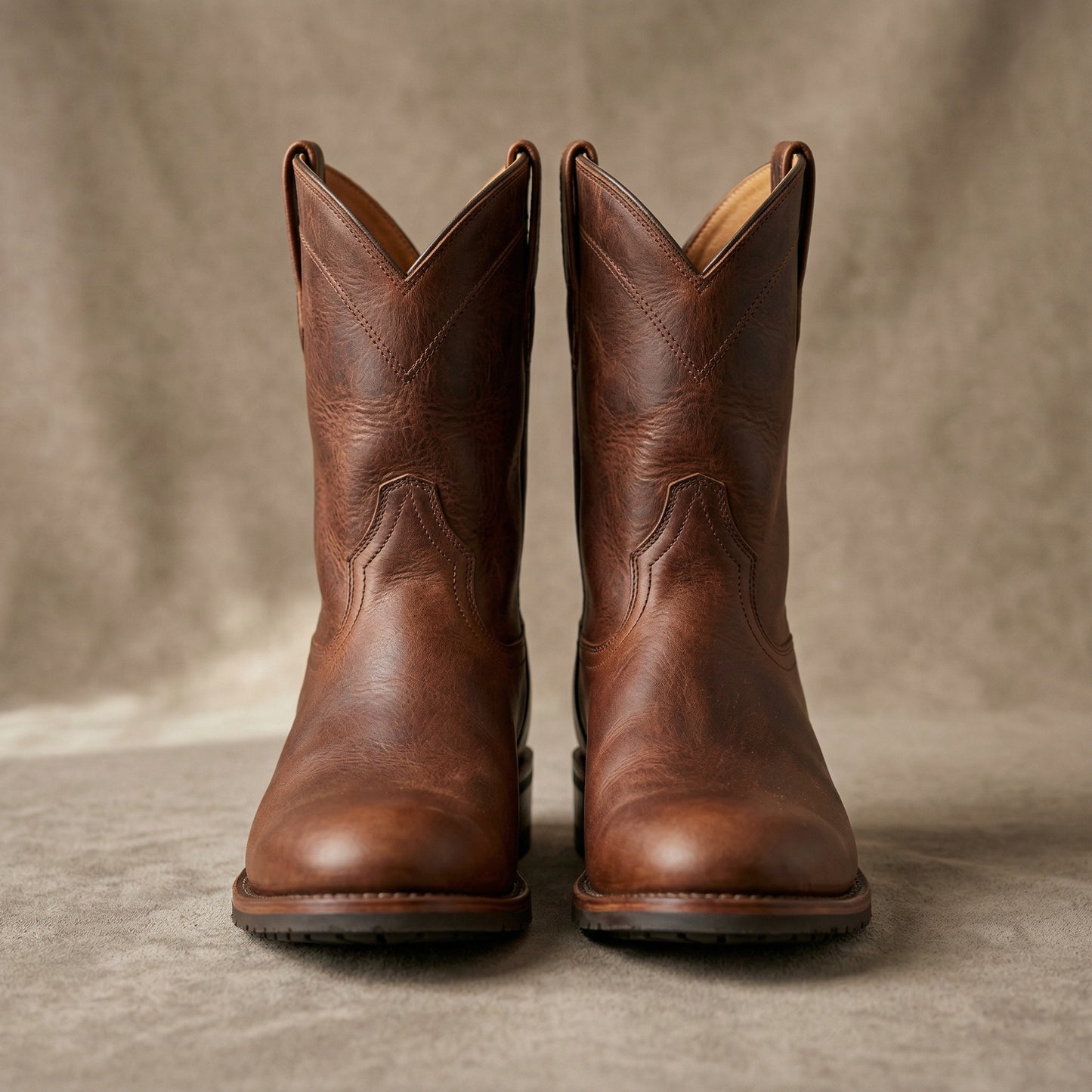 Pair of brown leather boots on a neutral background
