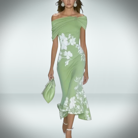 Woman wearing a green dress with white floral patterns on a plain background